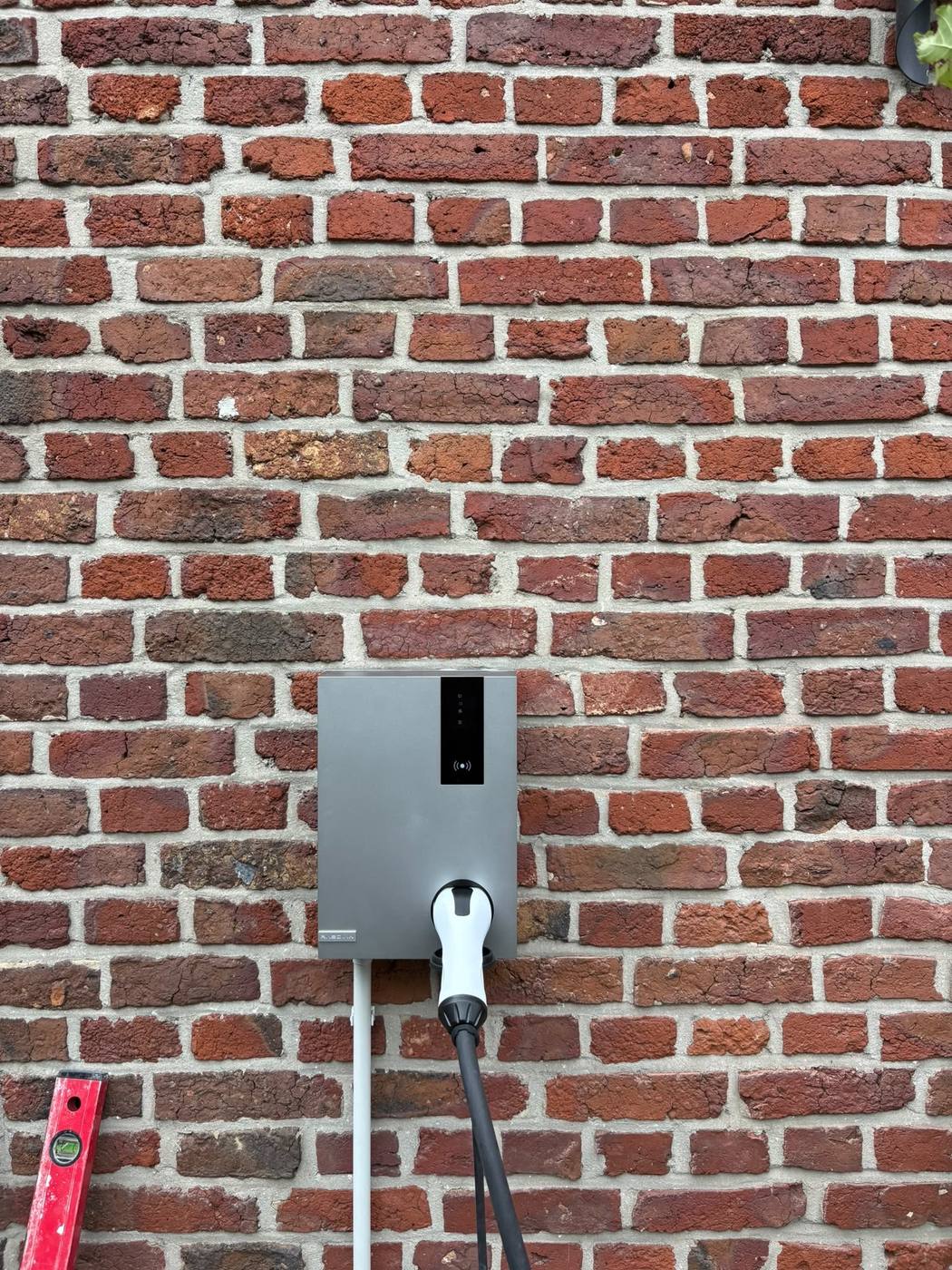 Laadpaal geplaatst op de gevel, laadkabel aangesloten