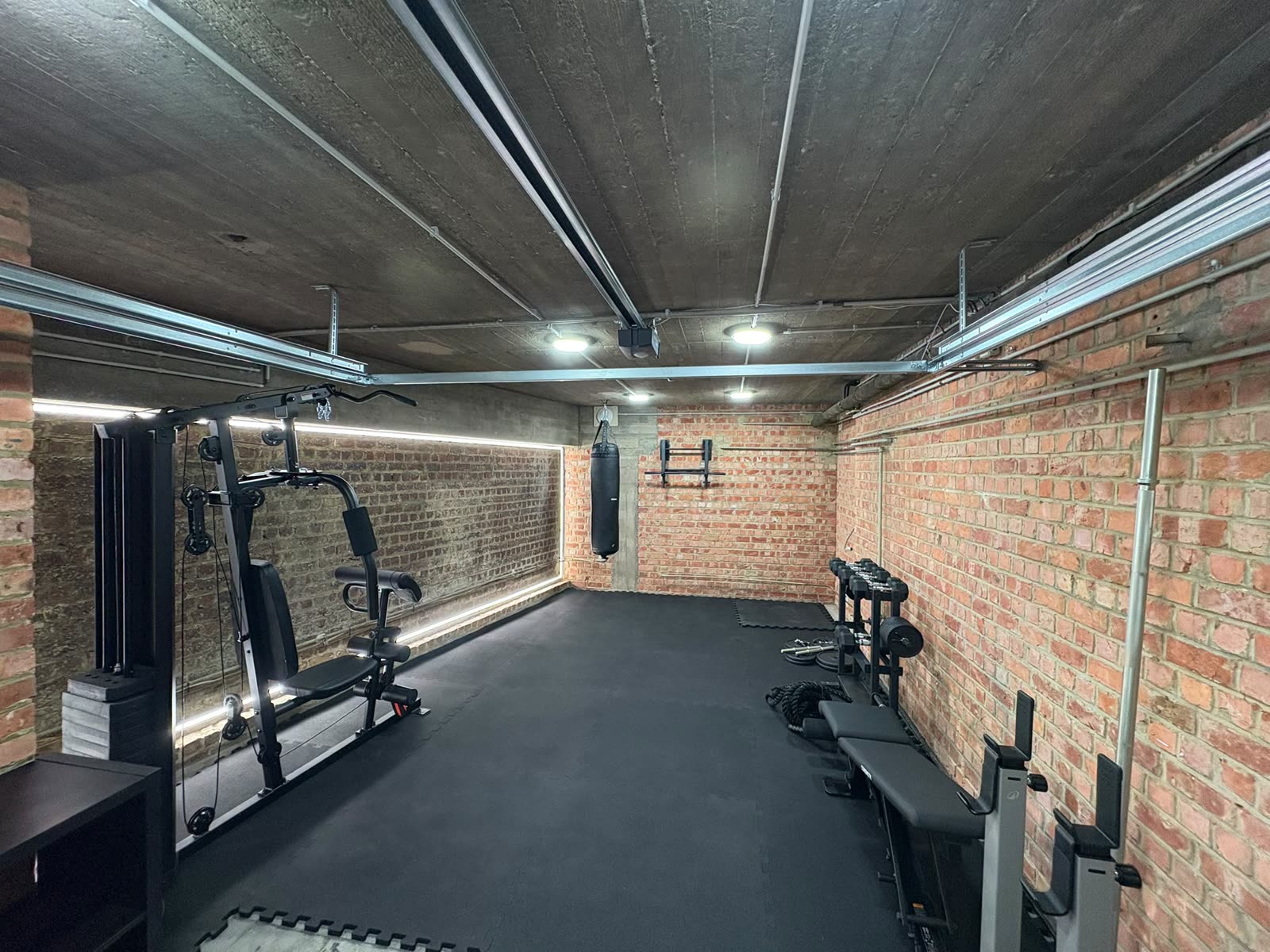Le garage devenu salle de sport : rubans LED le long des murs et plafonniers